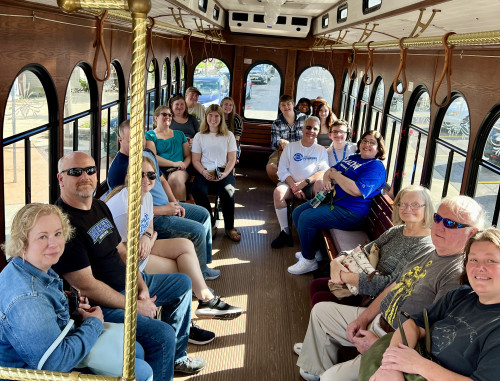 Various people in ˿Ƶ shirts riding trolley 